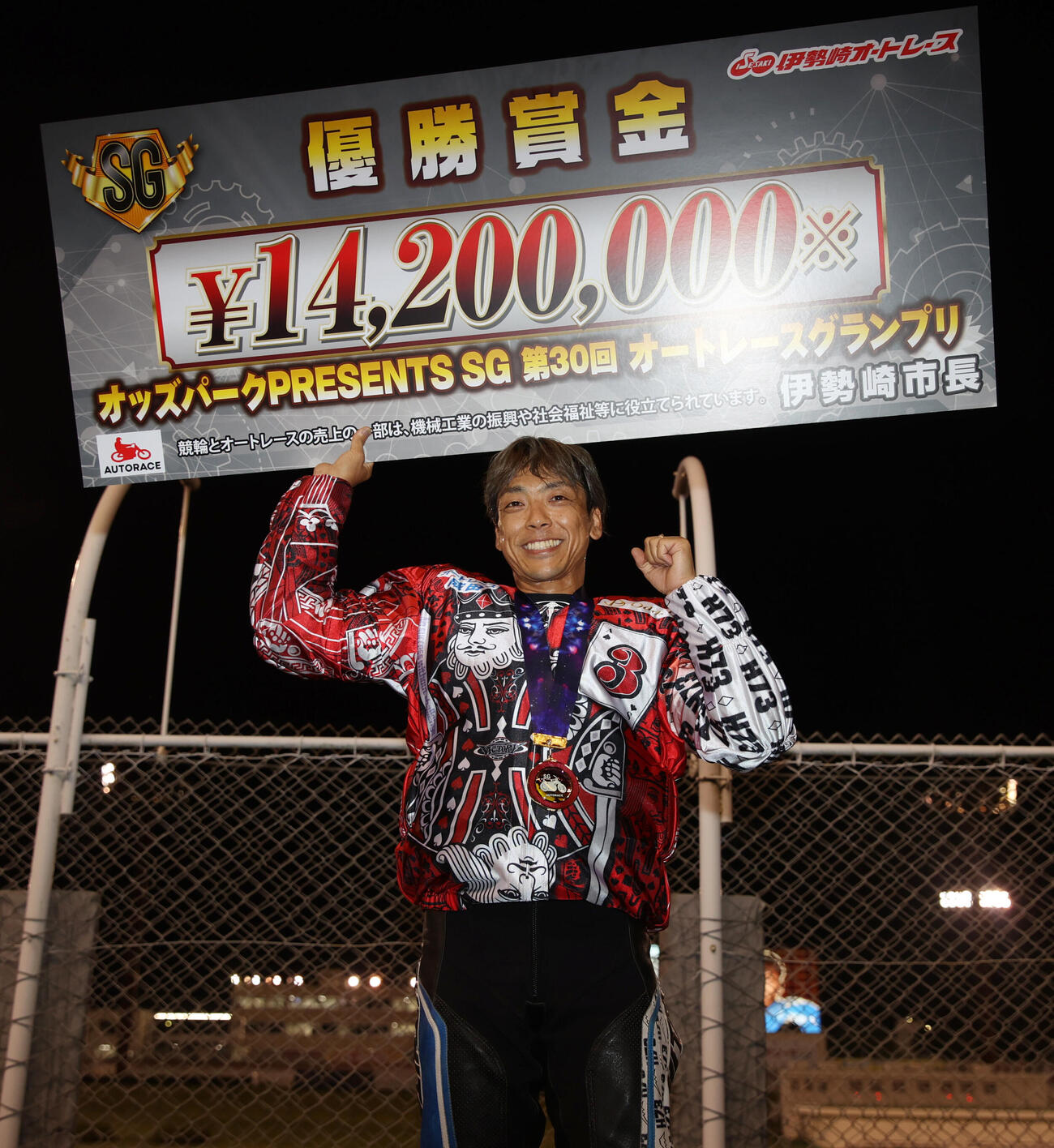 優勝した青山周平はガッツポーズで賞金ボードを掲げる（撮影・柴田隆二）