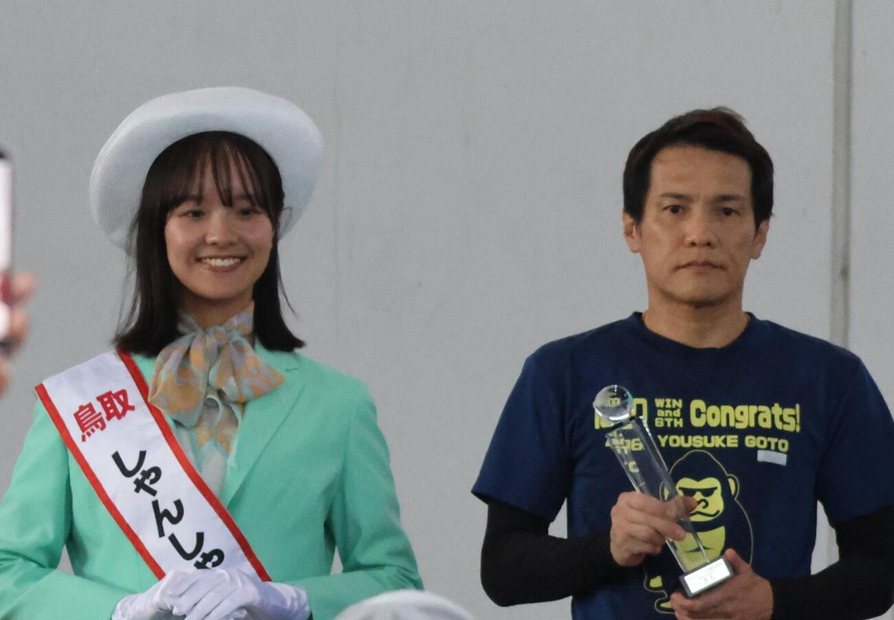 萩原秀人は優勝カップを手に鳥取しゃんしゃん鈴の音大使の松川星南さんと記念撮影（撮影・北條直治）
