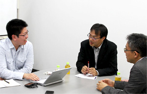 岡山デスク（左から２人目）に語りかける古村記者（左）