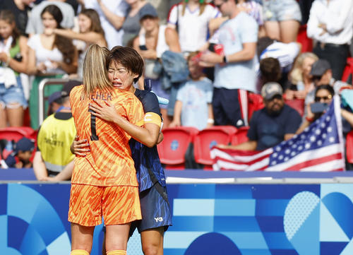 延長戦の末、準々決勝で敗退が決まり、米国のGKネイハーと健闘をたたえ合う熊谷（右）（共同）