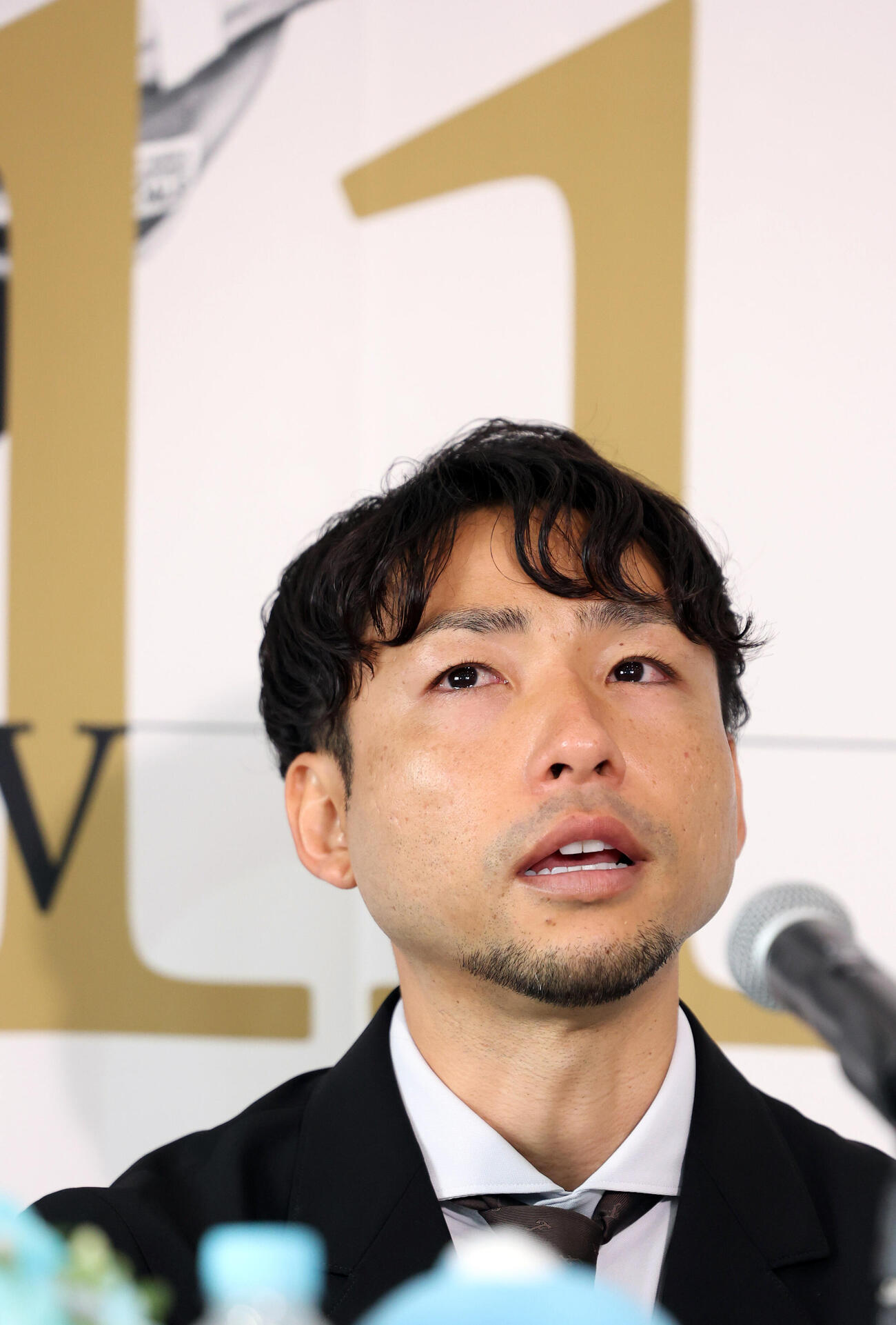 背番号11のボードを背に涙をこらえて会見する川﨑F小林悠（撮影・浅見桂子）