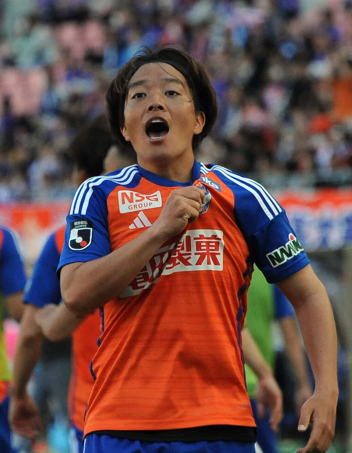 0－1の後半追加タイム4分に同点ゴールを奪い、胸のエンブレムをつかみながらサポータの声援に応える新潟・高木