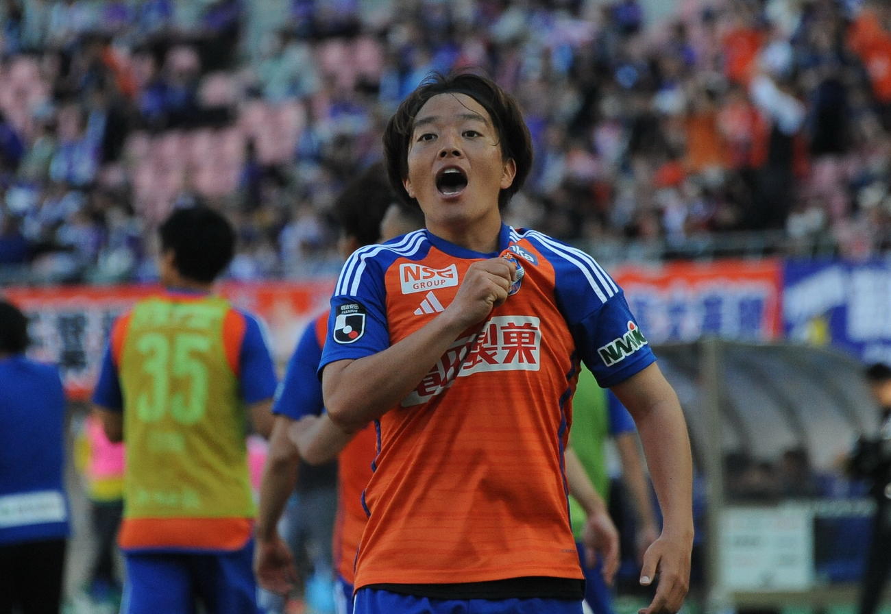 0－1の後半追加タイム4分に同点ゴールを奪い、胸のエンブレムをつかみながらサポータの声援に応える新潟・高木