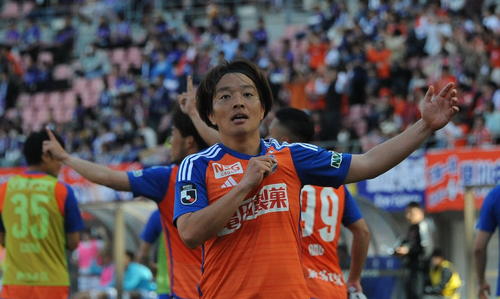 0－1の後半追加タイム4分に同点ゴールを奪い、胸のエンブレムをつかみながらサポータの声援に応える新潟・高木