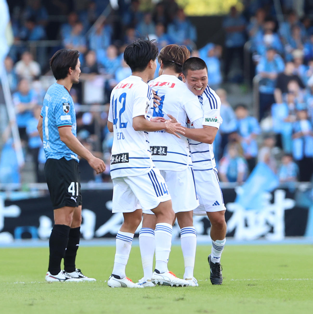 川崎F対新潟　前半、ゴールを決めイレブンに祝福される新潟小見（右）（撮影・水谷安孝）