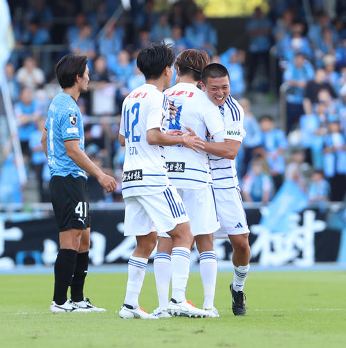 川崎F対新潟　前半、ゴールを決めイレブンに祝福される新潟小見（右）（撮影・水谷安孝）