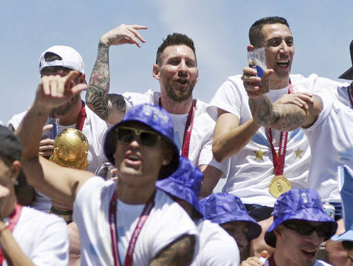 20日、アルゼンチン・ブエノスアイレスの凱旋（がいせん）パレードで、笑顔を見せるメッシ選手（奥中央）ら（ロイター＝共同）