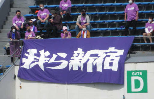 「我ら新宿」の横断幕を掲げるクリアソン新宿のサポーター