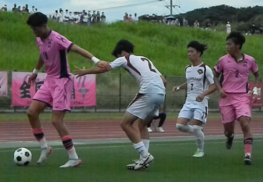 日大藤沢の198センチの超大型FW森重（左）のボールを奪いにかかる橘DF菊池（2番）