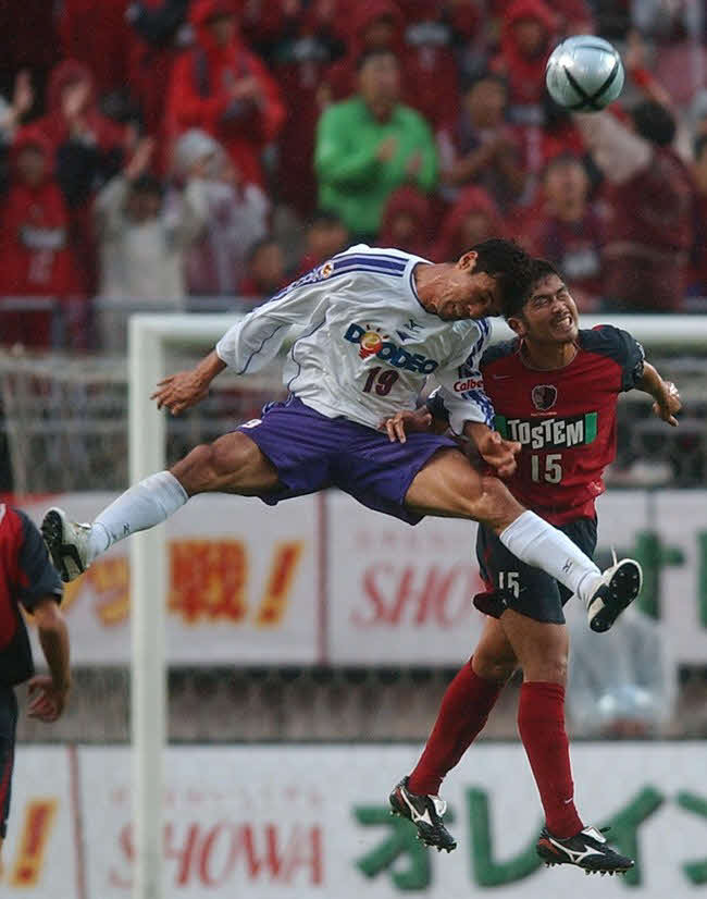 競り合う広島の盛田（左）と鹿島岩政（2004年10月3日）