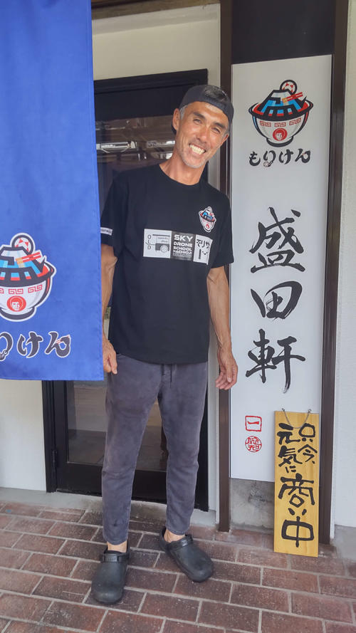盛田軒の前で笑顔を見せる盛田剛平さん
