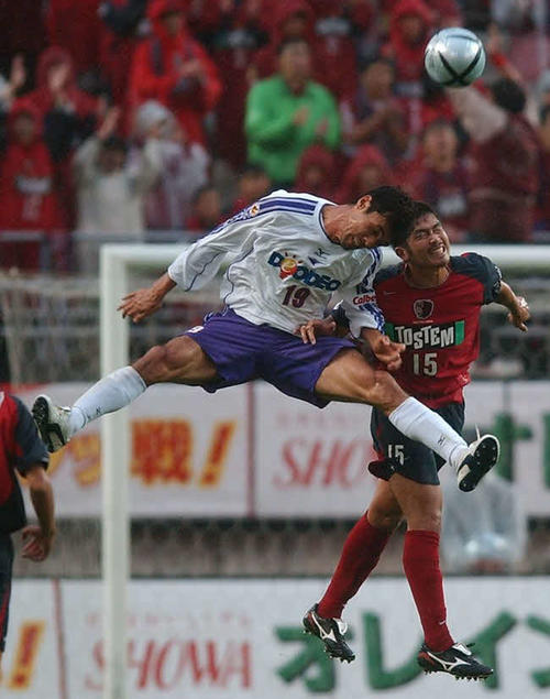 競り合う広島の盛田（左）と鹿島岩政（2004年10月3日）