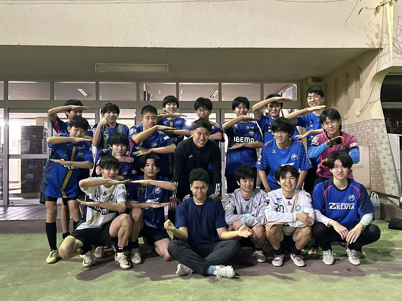 練習を終えて笑顔で記念撮影に収まる太田宏介さん（真ん中）