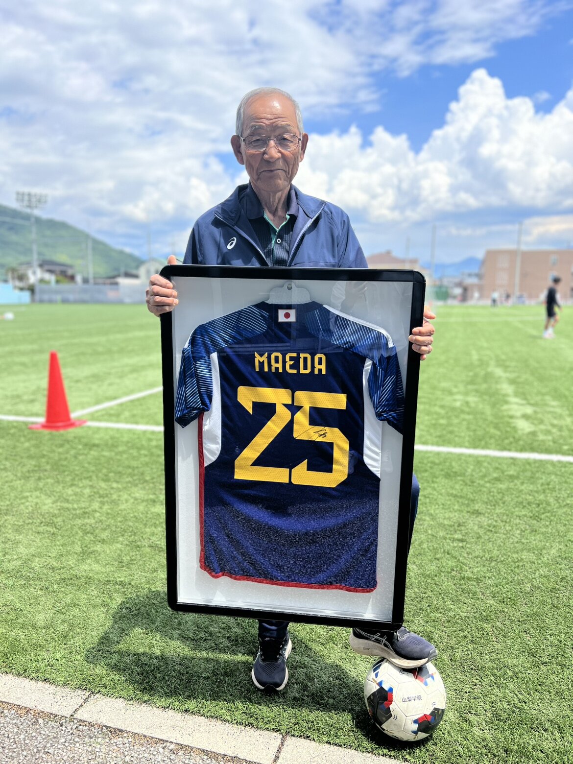 前回カタール大会出場時の前田大然のユニホームを持つ山梨学院高サッカー部の横森巧総監督