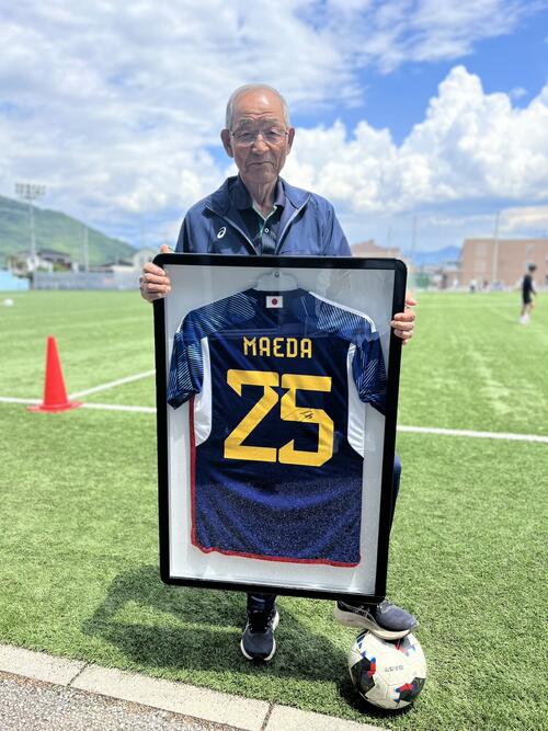 前回カタール大会出場時の前田大然のユニホームを持つ山梨学院高サッカー部の横森巧総監督