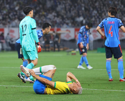 日本対ブラジル　後半、ゴール前でこぼれ球を詰めようとしたリシャルリソン（手前）は遠藤に倒され、足を押さえながら痛がる（撮影・垰建太）