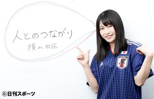 日本代表ユニホームを着て「人とのつながり」と書き込む横山由依