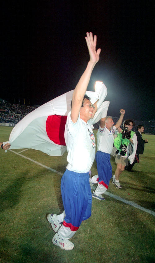 W杯アジア最終予選　イラン対日本　W杯出場を決めサポーターの声援に日の丸を掲げ応える岡田武史監督（1997年11月16日撮影)　
