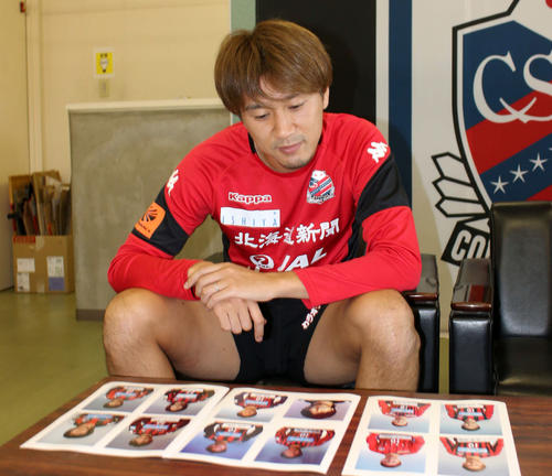 12シーズン分の自身の顔写真を見ながら振り返る札幌ＭＦ宮沢主将（撮影・保坂果那）