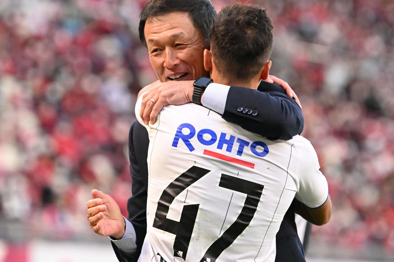 鹿島対G大阪　試合後、J1残留が決まりG大阪ファン・アラーノ（手前）と抱き合って喜ぶ松田監督（2022年11月5日撮影）