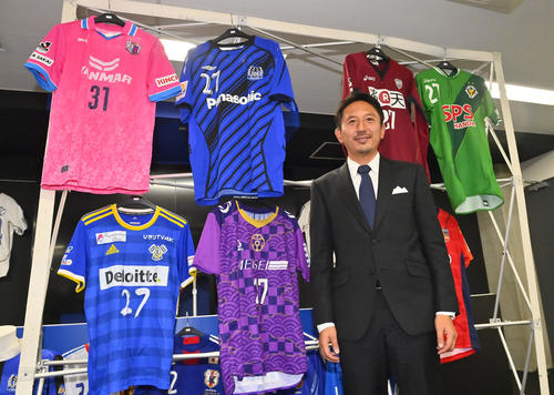 引退会見を行い、所属したユニホームを背に笑顔を見せる橋本（撮影・和賀正仁）