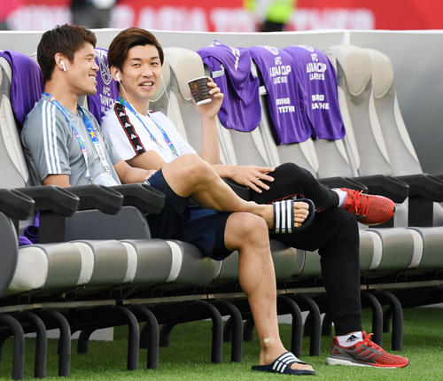 日本対オマーン　試合前、飲み物を片手にベンチでリラックスする大迫（右）。左は酒井（撮影・横山健太）