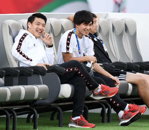 日本対オマーン　試合前、ベンチで談笑する堂安（左）と南野（撮影・横山健太）