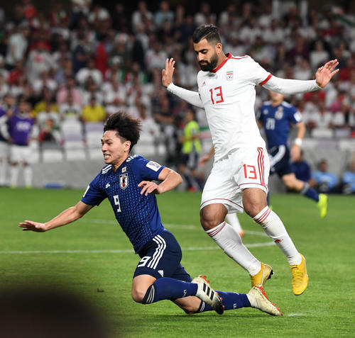 日本対イラン 後半、南野(左)はカナニに倒される(撮影・横山健太)