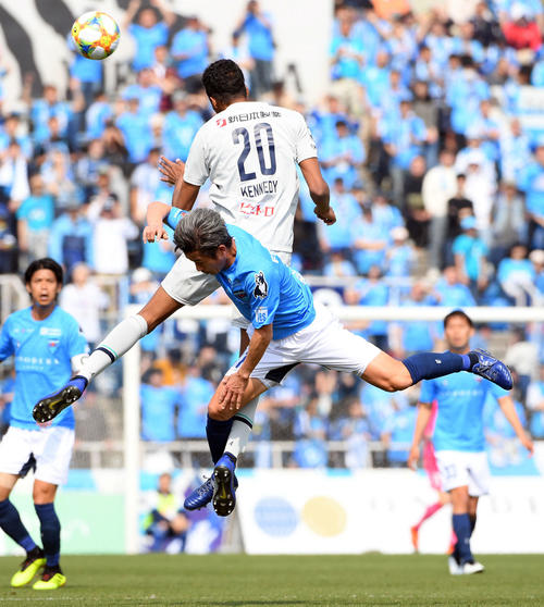 横浜FC対福岡　前半、福岡DF三国ケネディエブス（後方）と競り合う横浜FC・FWカズ（撮影・たえ見朱実）