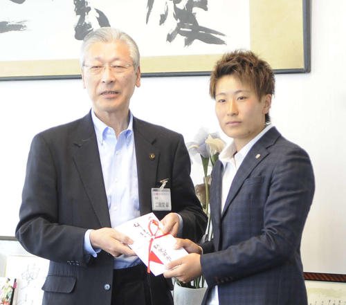 新発田市の二階堂市長（左）から支援金の目録を贈呈され、やや緊張気味の平尾