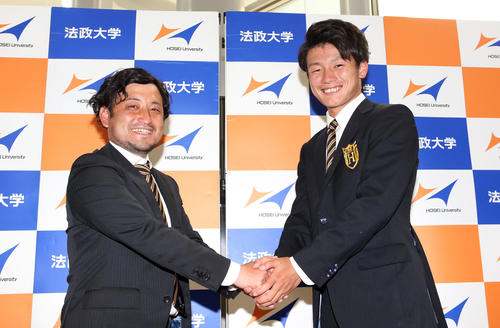 南米選手権の日本代表に選ばれ、大学構内で記者会見を行い、法大・長山監督（左）と握手を交わす上田（撮影・狩俣裕三）