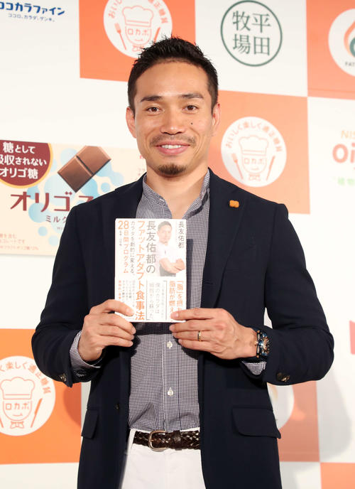 著書を手に写真に納まる長友佑都（撮影・鈴木正人）