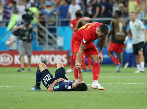 試合が終了し、ピッチに倒れ込んだ香川真司を起こそうと手をつかむE・アザール（2018年7月2日撮影・PNP）