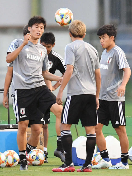 日本代表の練習で、ボールを使って体を動かすDF冨安。右はMF久保（撮影・加藤諒）