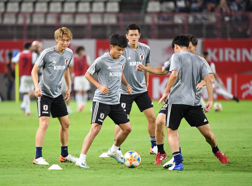 試合開始前、ピッチで体を動かす久保建英（左から2人目）ら日本代表の選手たち（撮影・加藤諒）