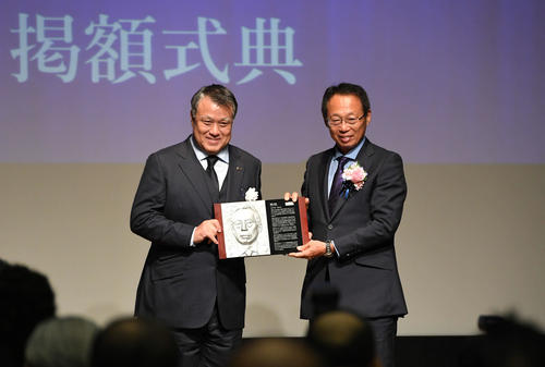 日本サッカー殿堂の掲額式で岡田氏（右）は田嶋幸三会長からレリーフを受け取る（撮影・山崎安昭）