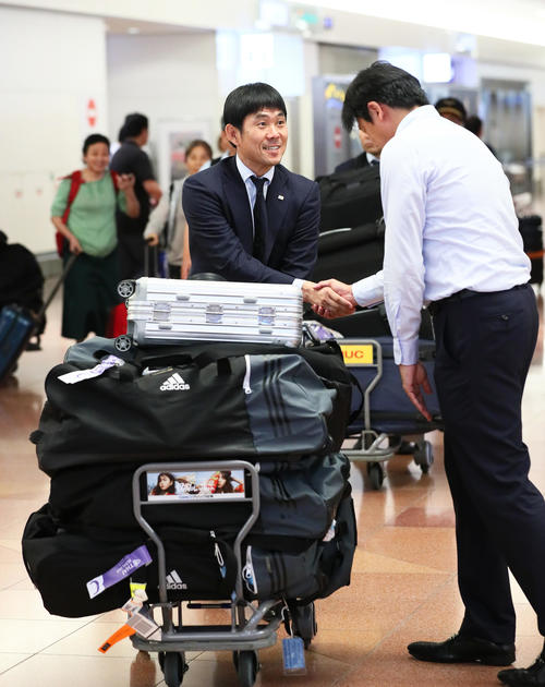 帰国し代表スタッフと笑顔で握手を交わす森保監督（撮影・足立雅史）
