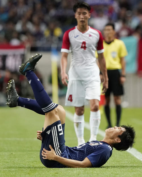 日本－モンゴル　試合終了間際、顔をしかめてピッチに倒れ込む冨安（共同）