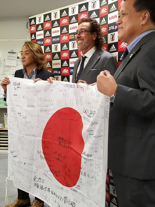 ビーチサッカーW杯を前にメッセージ入りの日の丸を贈られ笑顔を見せるラモス瑠偉監督(中央)。左は北沢ビーチサッカー委員長、右は日本協会の田嶋会長