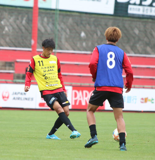 パスを出す札幌DF田中（左）（2019年8月13日撮影）