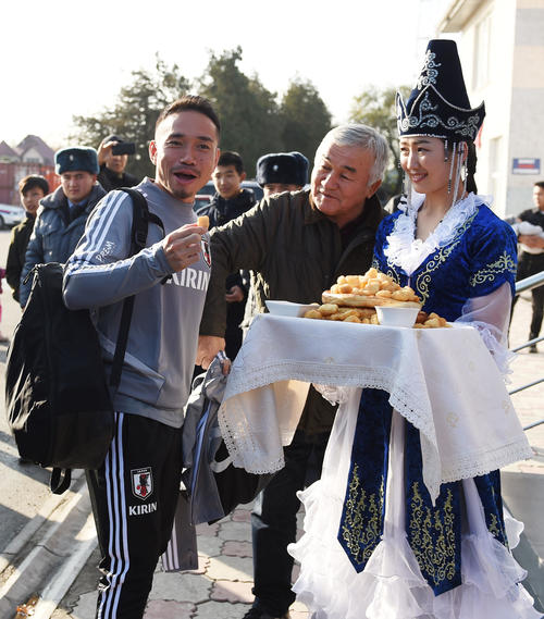 歓迎料理のボルソックを手に笑顔を見せる長友（左）（撮影・横山健太）