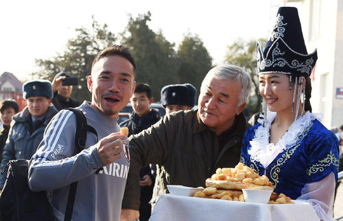 歓迎料理のボルソックを手に笑顔を見せる長友（左）（撮影・横山健太）