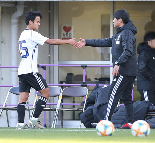 広島との練習試合の後半、出場前に監督代行の横内コーチ（右）と握手を交わす久保（撮影・河野匠）