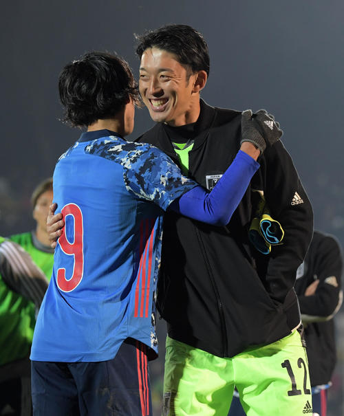 キルギスに勝利し笑顔で抱き合うGK権田（右）と南野（撮影・横山健太）