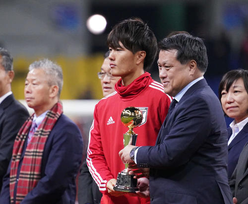 東アジアE－1選手権で得点王に輝き、表彰式でJFAの田嶋会長（右）からトロフィーを受け取る小川（撮影・加藤諒）