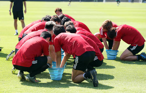 暑さ対策で氷水の入ったバケツに手を入れるU－23日本代表の選手たち（撮影・前田充）