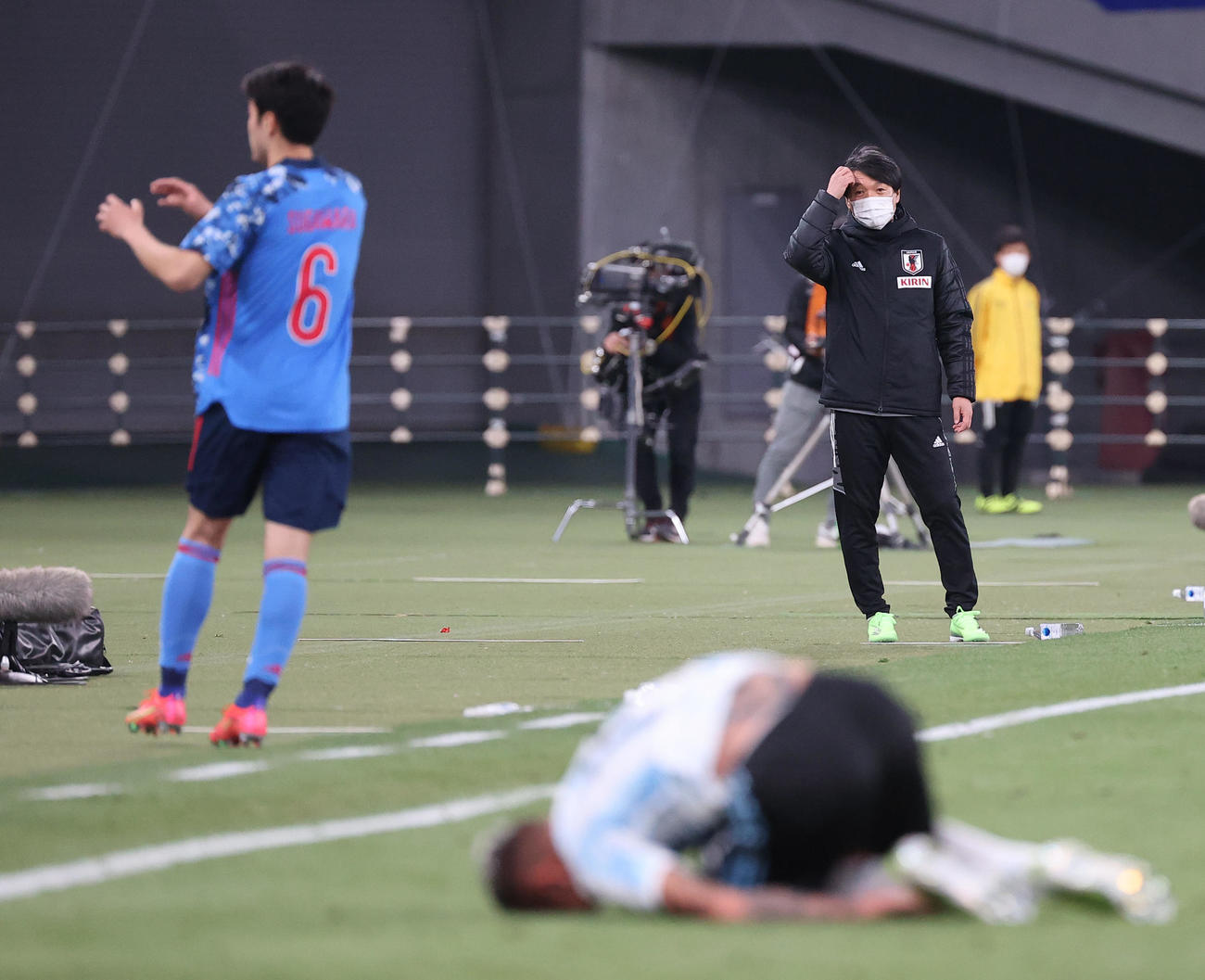 日本対アルゼンチン　前半、頭をかきながら戦況を見つめるU－24日本の横内監督（右）（撮影・垰建太）