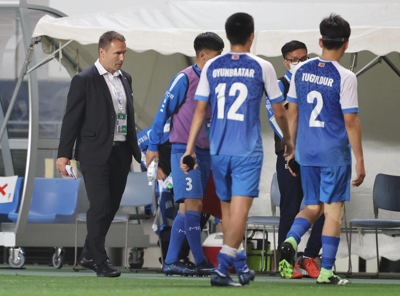 日本対モンゴル　日本に大敗を喫し厳しい表情で引き揚げるモンゴル代表ボジク監督（左）（撮影・垰建太）