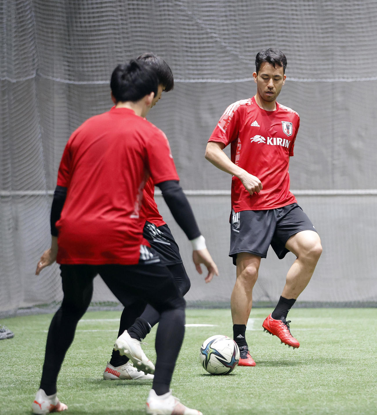 札幌ドームの室内でボール回しをするDF吉田（右）（代表撮影）