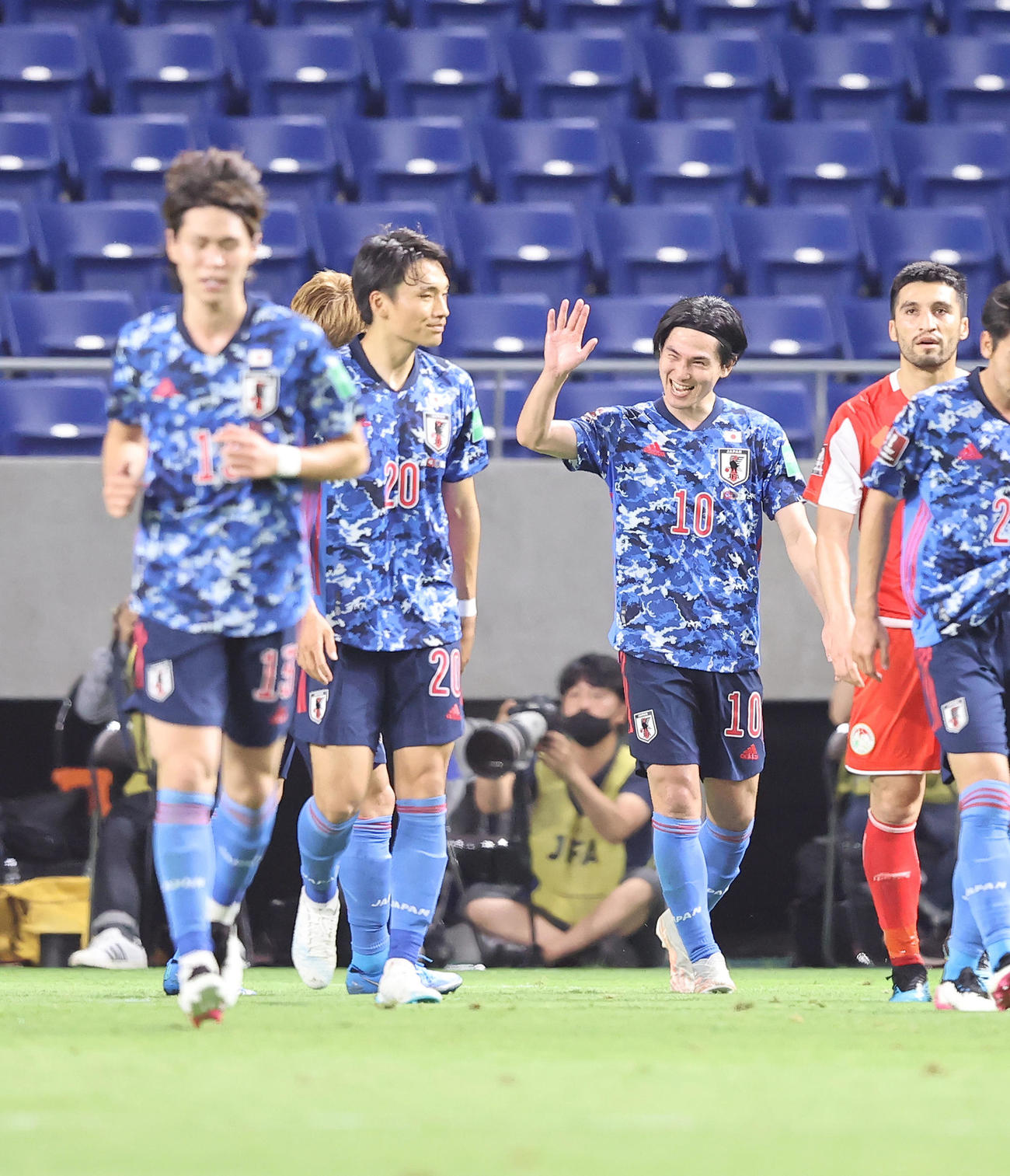 日本対タジキスタン　前半、ゴールを決めた南野（中央）は笑顔でタッチを交わす（撮影・垰建太）
